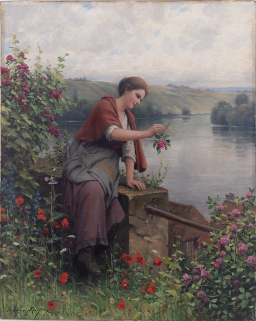 Single figure woman sitting by the water with a rose in her hand looking like she may drop it in the water